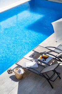 a table and chair next to a swimming pool at Apartamentos Vistamar II in Playa d'en Bossa