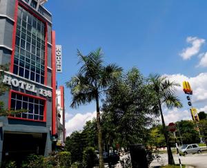 un hotel con una palmera frente a un edificio en Hotel 138 @ Bestari, en Shah Alam
