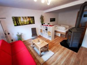 sala de estar con sofá rojo y cama en Ferienappartement -Hof Baum, en Hunswinkel