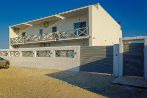 a white house with a gate and a fence at White Vama Veche in Vama Veche