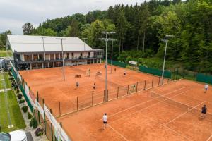 a group of people playing tennis on a tennis court at Center Vintgar in Slovenska Bistrica