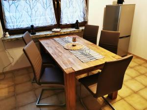 una mesa de madera en una cocina con sillas alrededor en Ferienappartement -Hof Baum, en Hunswinkel
