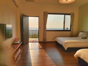 a bedroom with two beds and a large window at Chi House in Miaoli
