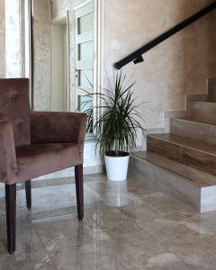 a chair and a plant in a room with stairs at Panorama apartments in Veliko Gradište