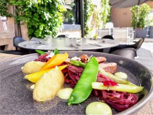 een bord met groenten op tafel bij Hotel La Couronne in Ensisheim