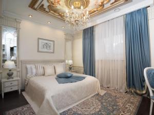 Un dormitorio con una cama grande y una lámpara de araña. en Hotel Volga, en Engels