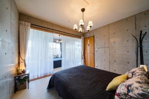 a bedroom with a large bed and a large window at EM Tree House in Uruma