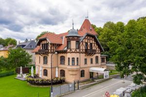 une grande maison avec une tourelle dans une rue dans l'établissement Vila ELIS, à Jeseník