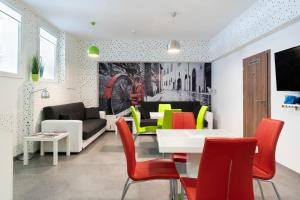 a living room with a table and colorful chairs at Vajda 15 Hostel Budapest in Budapest
