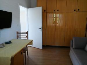 un soggiorno con una grande porta bianca e un divano di Apartment Pehi a Supetar (San Pietro di Brazza)