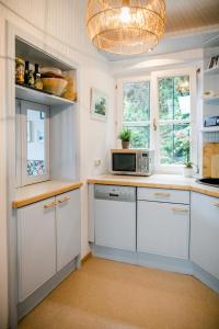 a kitchen with white cabinets and a microwave at Hallstatt Lake View House in Hallstatt