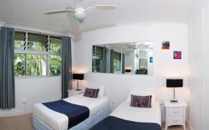 a bedroom with two beds and a mirror at Poinciana 112 Bedrooms x3 Free Buggy in Hamilton Island +23 photos