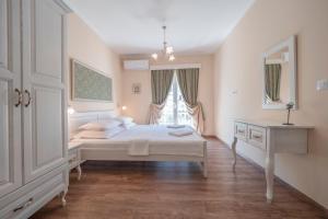 een witte slaapkamer met een bed en een raam bij Marinero Apartments in Budva