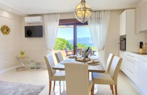 kuchnia i jadalnia ze stołem i krzesłami w obiekcie Luxury Apartments Villa Stina w Krku