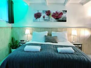 een slaapkamer met een groot bed met 2 kussens erop bij Amsterdam Home in Amsterdam