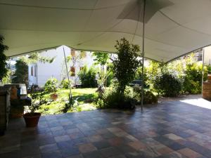 una gran tienda blanca en un jardín con un árbol en Le Viole B&B, en Mergo