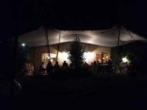 a group of people sitting under a white tent at night at Le Viole B&B in Mergo