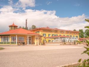 ein großes gelbes Gebäude mit rotem Dach in der Unterkunft Björkbackens Karaktärshotell in Vimmerby