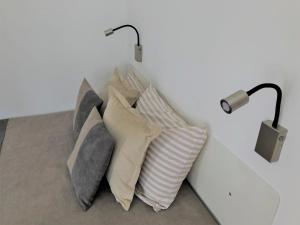 a pile of pillows sitting next to a wall with a lamp at Apartment Auer_Belgrade in Belgrade