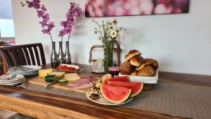 a table with a tray of bread and fruit on it at Vakantiehuisje Winterberg in Winterberg