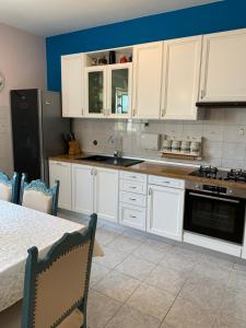 a kitchen with white cabinets and a sink and a table at Holiday Home Endi in Unešić