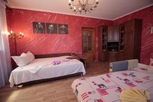 カロリノ・ブハスにあるGuest House Kamenny Domの赤い壁のベッドルーム1室(ベッド2台付)