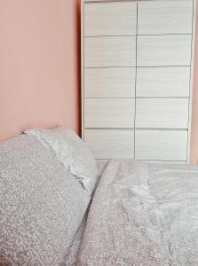 a bedroom with a white bed and a dresser at Apartament One Divine - Zarnesti in Zărneşti