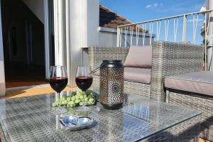 zwei Gläser Wein auf einem Glastisch auf einem Balkon in der Unterkunft Wohnstation DIAMOND SUITE in Subingen
