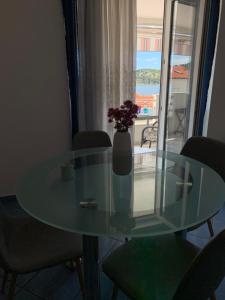 a glass table with a vase with flowers on it at Villa Linda in Ražanj