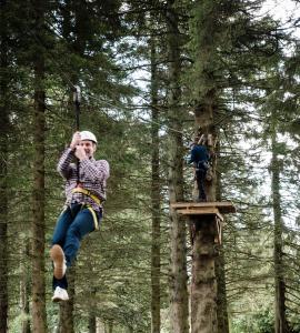a woman is hanging from a tree swing at The Gleneagles Hotel in Auchterarder