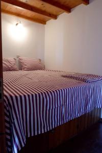 1 dormitorio con 1 cama con manta a rayas en Asiminas House, en Symi