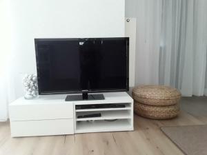 een flatscreen-tv zittend op een wit entertainment center bij Freundliche Ferienwohnung mit großer Terasse in Aichstetten