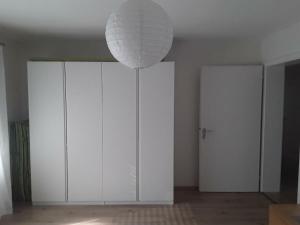 a room with white cabinets and a white light fixture at Freundliche Ferienwohnung mit großer Terasse in Aichstetten +9 photos