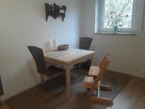 a wooden table and chairs in a room with a window at Freundliche Ferienwohnung mit großer Terasse in Aichstetten
