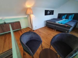 ein Wohnzimmer mit 2 Stühlen und einem Bett in der Unterkunft Wohnstation DIAMOND SUITE in Subingen