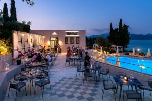 a restaurant with tables and chairs and a pool at Porto Galini Seaside Resort & Spa in Nikiana