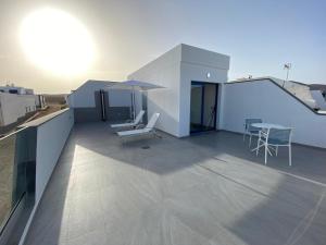 a balcony with chairs and a table on a roof at La Pardela Exclusive Apartamentos in Caleta de Sebo