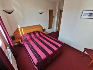 a small bedroom with a bed with a pink blanket at La Consigne Caen Gare SNCF Centre in Caen