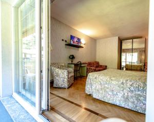 a bedroom with a bed and a living room at Hotel Pian Nava in Premeno