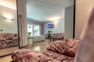 a living room with a bed and a mirror at Hotel Pian Nava in Premeno