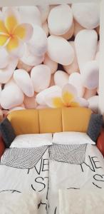 a couch in front of a wall of flowers at Happy apartment in Zalakaros