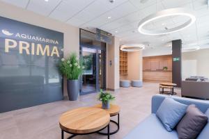 an office lobby with a couch and a table at Aquamarina Prima Gold in Międzyzdroje