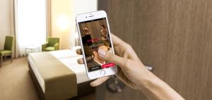 a person taking a picture of a hotel room with their cell phone at IntercityHotel Braunschweig in Braunschweig