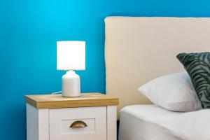 a bedside table with a lamp on it next to a bed at Hostel Globo in Šibenik