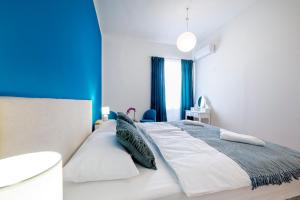 a bedroom with a large white bed with blue walls at Hostel Globo in Šibenik