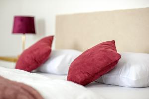 two red pillows sitting on top of a bed at Hostel Globo in Šibenik