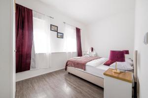 a bedroom with a bed and a table with a lamp at Hostel Globo in Šibenik