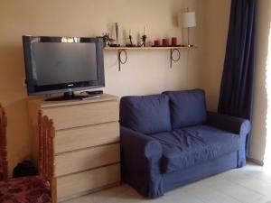 a living room with a blue couch and a tv at Apartament Morskie Oko in Międzyzdroje