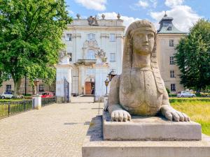 uma estátua de uma mulher em frente a um edifício em Hotel Zamek Królewski w Rydzynie em Rydzyna