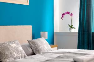 1 dormitorio con 1 cama y un jarrón con flores púrpuras en Globo - self check-in hostel, en Šibenik